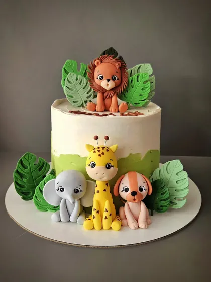 I love making jungle theme cakes! This one features a whole crew of hand-sculpted fondant animals, including a lion, elephant, giraffe, and dog, surrounded by tropical leaves.
