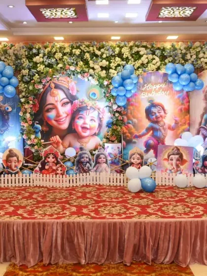 A close-up of the elaborate stage backdrop for a Krishna-themed first birthday.