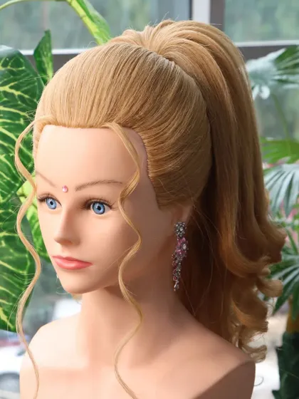 A pop-out unicorn ponytail hairstyle. This is a trendy and modern look with a high, sleek ponytail and soft curls, perfect for a party or sangeet.