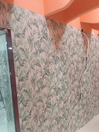 Another view of the palm leaf wallpaper, showing how it can be used to cover a long wall and create a continuous, cohesive look. The pattern brings energy and life to the hallway.