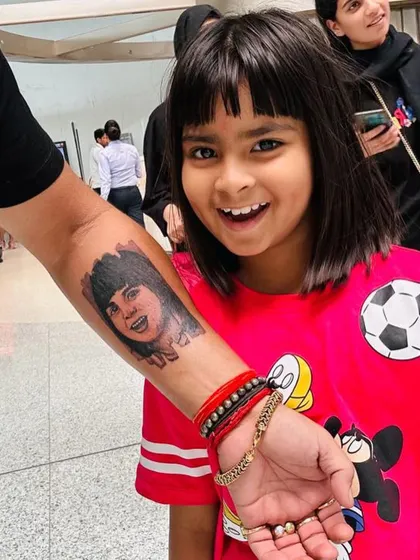 There is nothing more special than capturing a loved one in a permanent portrait. We worked closely with this client to create a realistic tattoo of his daughter, focusing on her joyful expression. Seeing the finished tattoo next to her photo shows the level of detail and likeness we strive for in our portrait work.