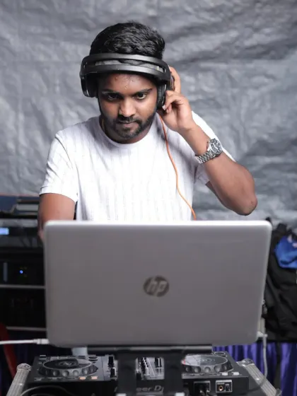 Listening closely to cue up the next track. Every transition is planned to maintain the party's momentum.