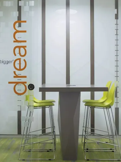 A breakout high-table area at CorporatEdge, featuring motivational graphics on the glass partition. These small, informal zones are designed to inspire creativity and quick collaboration.
