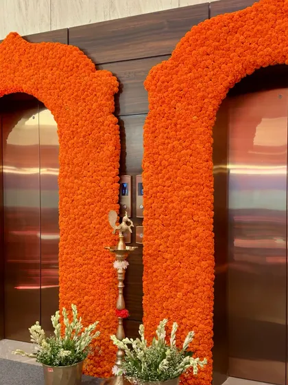 The combination of bright orange marigolds, white tuberoses, and a traditional brass lamp (diya) creates a warm and auspicious welcome. This setup is perfect for bringing blessings and color to any pre-wedding function.