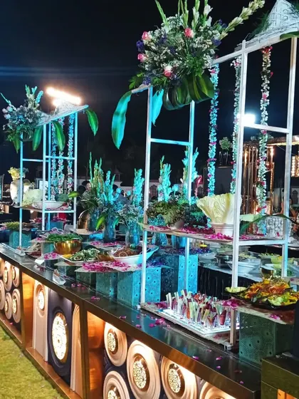Another angle of the grand outdoor salad station, showing the intricate floral work and the depth of the food display for a large gathering.