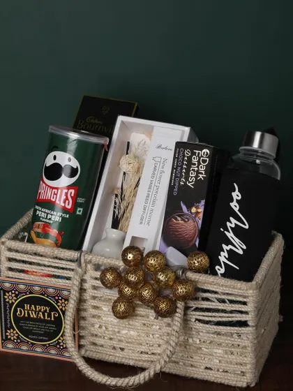 This jute-handled basket is packed with snacks and useful items. It includes Pringles, a personalized bottle, a reed diffuser, and chocolates, making it a great all-rounder gift.