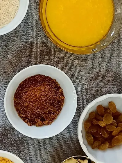 Ingredients like ghee, rice, and raisins are ready for making the sweet 'Chakara Pongal'.