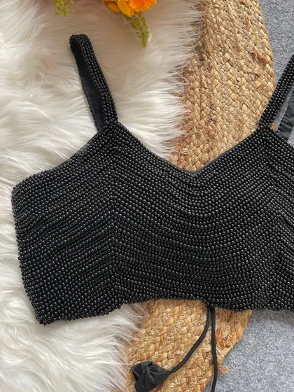 A close-up of the intricate pearl work on the black spaghetti blouse.