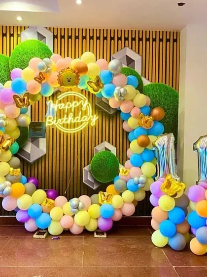 A colorful and cheerful 11th birthday celebration. This circular balloon arch uses a rainbow of pastel colors, with a neon sign and number balloons indicating the age.
