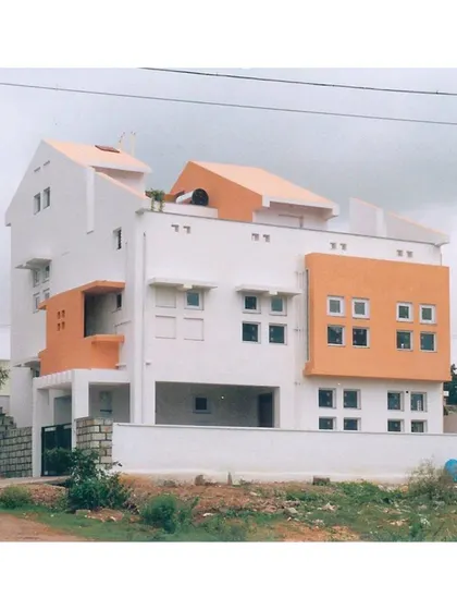 The varied rooflines and window placements of 'Nachiar Illam'. The design corresponds to the site's incline, creating a dynamic silhouette against the sky.