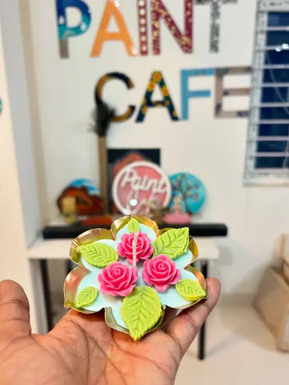 A single, large floating candle with pink roses and green leaves, made from soy wax.