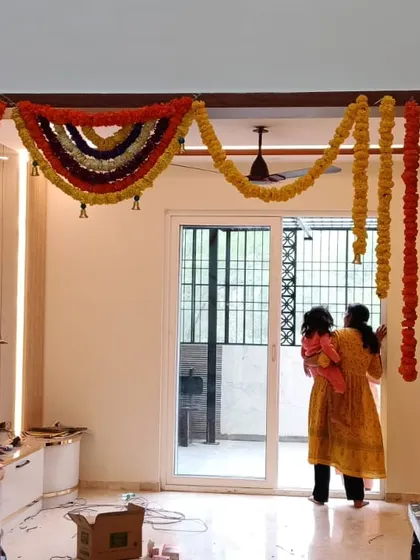 This is a traditional housewarming (gruhapravesam) entrance decoration. I used marigold and other fresh flower garlands to frame the main doorway, a standard practice for auspicious occasions.