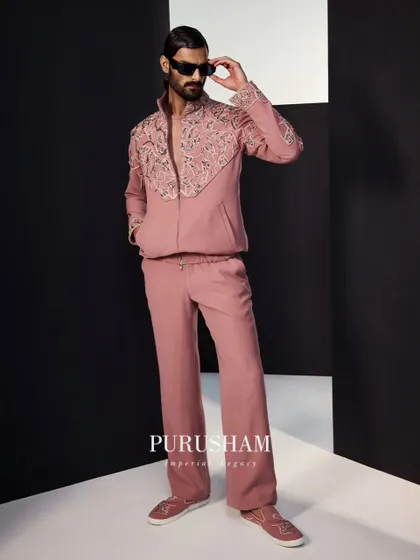 A full-length view of the dusty rose bomber set. The relaxed fit of the trousers paired with the structured, embroidered jacket creates a balanced and stylish silhouette.