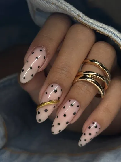 A full view of the polka dot manicure, showing how the gold accents are placed on different nails for a balanced and artistic effect.