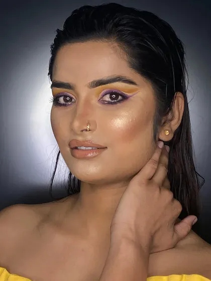 A high-fashion portfolio look created at our academy. The image showcases a graphic eyeliner in yellow and purple, demonstrating skills in precision and color theory.