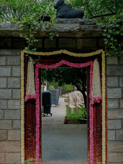 An entrance framed with pink and yellow floral garlands.