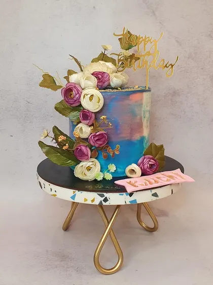 I love playing with colors, and this buttercream cake is like a painted canvas. I used a palette knife to create a multi-toned watercolor effect and then arranged a cascade of beautiful, handmade sugar flowers.