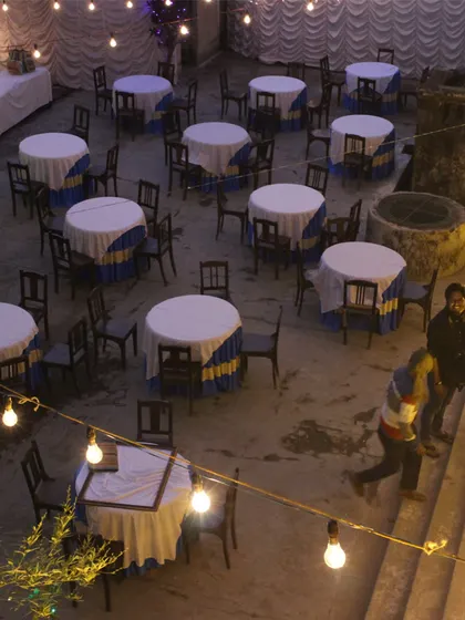 The courtyard of a heritage home set up for a community dinner. Simple additions like string lights and tables can completely change the atmosphere of a place, making it a venue for shared experiences.