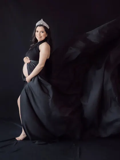 A queen awaiting her heir. The crown and the dramatic black flowing gown create a regal and powerful maternity portrait.