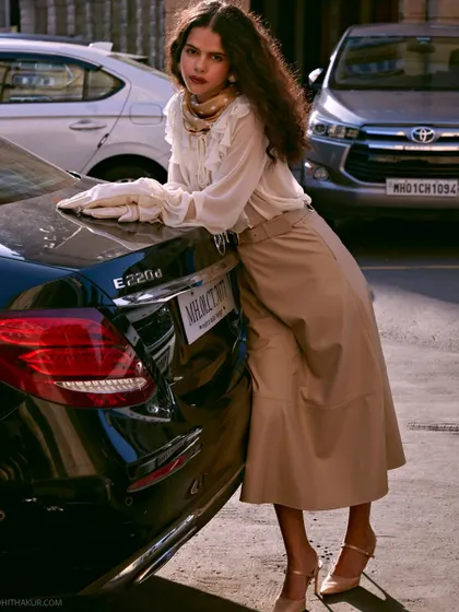 A slightly different angle that captures the same mood of timeless glamour. The focus on the texture of the skirt and the soft ruffles of the blouse highlights the quality of the garments.