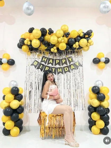 A full view of the simple birthday backdrop with balloon pillars on the sides.