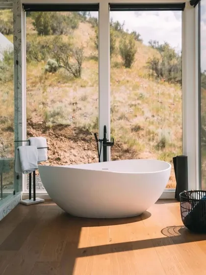 Another angle of the bathroom, showing the modern freestanding tub and minimalist fixtures. The design is all about creating a clean, tranquil space for relaxation.