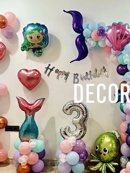 A simple yet charming mermaid-themed birthday decoration for a 3rd birthday. The setup uses various foil balloons, including a mermaid tail, octopus, and hearts, to create an underwater scene.