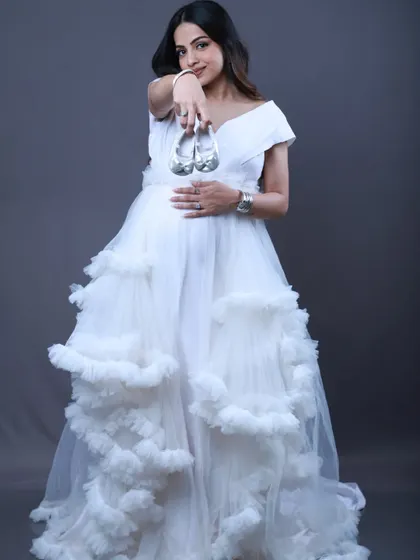 Get two looks in one with this convertible white maternity gown. It can be a sleek body-fit dress or a playful ruffle gown, giving you great variety for your photoshoot album.