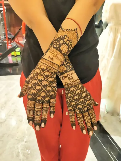 This design features a unique grid of mini elephants, a popular request for a modern yet traditional feel. The couple's names are also beautifully written into the design on the wrists.