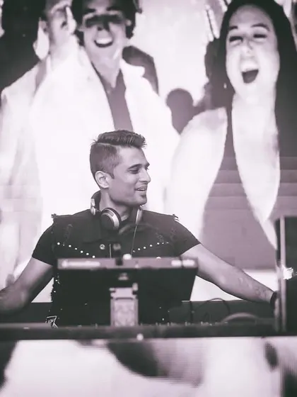 A black and white shot capturing the timeless feel of a retro night. The visuals on the screen behind me are from a classic Bollywood dance number, adding to the nostalgic atmosphere.