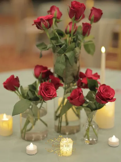 A collection of red roses in glass vases, used as a simple but beautiful centerpiece.