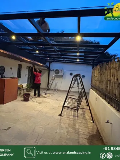 Our team is seen here giving the final touches to a clear glass pergola installation. We handle all fabrication and electrical work to ensure a seamless and professional execution for every project.