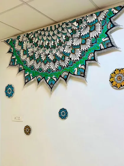 Another view of the peacock ceiling mandala, showing how it interacts with the smaller accent pieces on the wall to create a complete artistic installation.