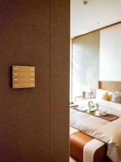 This Moorgen smart panel in a brushed metallic finish is installed beside a bedroom entrance. Its placement provides convenient control over the room's environment from the moment you enter or leave.