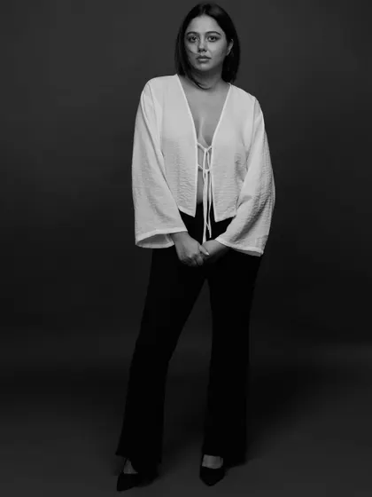 A full-length studio portrait in black and white. The simple, elegant styling and the soft, diffused light create a timeless and classic look.
