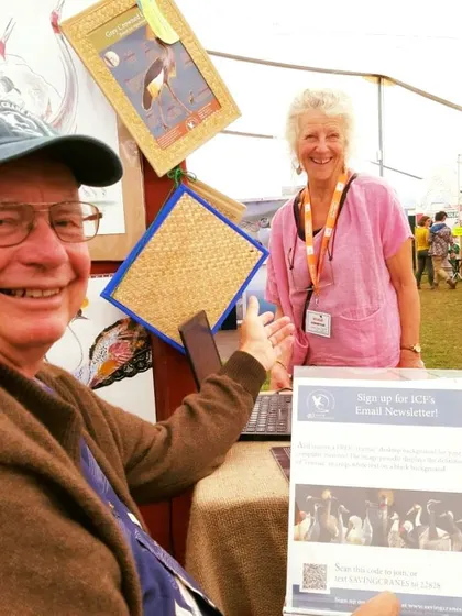 A visitor signing up for a newsletter at a partner's booth at the Global Birdfair. We actively collaborate with conservation organizations like the International Crane Foundation.