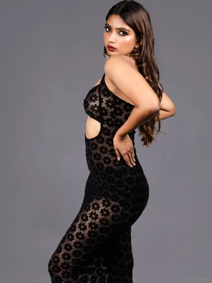 A side-profile shot of the model in the sheer dress, highlighting her curves.