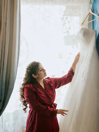 A quiet moment with her dress. The anticipation and excitement of the day are captured in this beautiful pre-wedding shot.