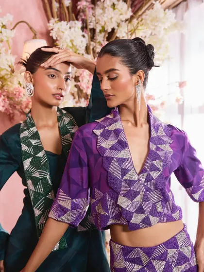 A close-up shot highlighting the interaction between two models and their complementary makeup. The look features a subtle shimmer on the eyes and a soft pink lip, perfect for festive occasions.