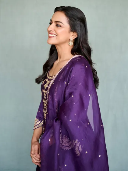 A candid, smiling shot of Shraddha in her purple suit. It shows that traditional wear can be both regal and comfortable.