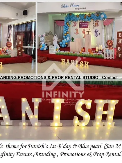This simple jungle theme for a first birthday at Blue Pearl Banquet Hall features a character backdrop with a blue and gold balloon garland. The setup includes baby block props and marquee letters for a classic and charming look.