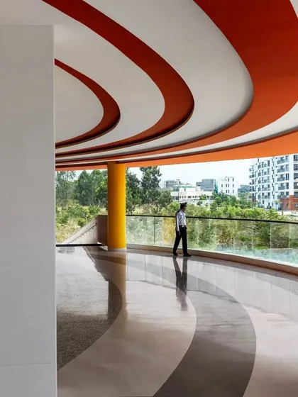 The expansive balcony of the MARC Auditorium serves as a pre-function area with panoramic views. The design emphasizes porosity and the seamless transition between inside and outside.