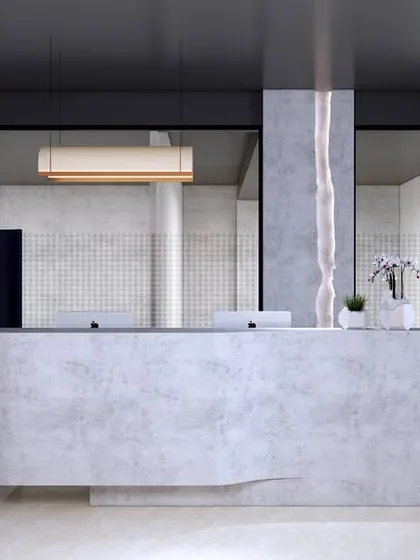 A render of a minimalist office reception area. The design uses a concrete-finish desk, wooden slats, and a bold blue screen to create a modern and welcoming first impression.