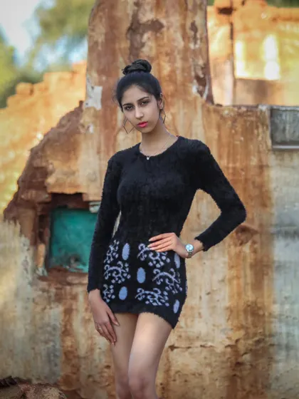 A confident pose against a textured, weathered wall. This kind of backdrop adds a lot of character to a portrait.