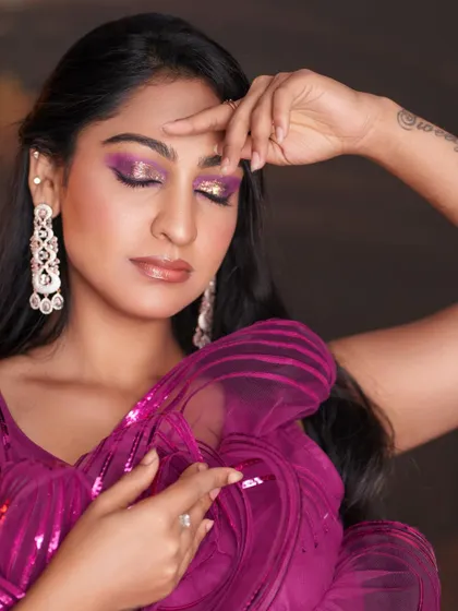 A creative pose highlighting the bold eye makeup.