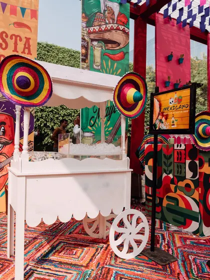 A charming food cart with colorful sombreros, set against the backdrop of the vibrant fiesta decor. This adds an interactive and fun element to the event.