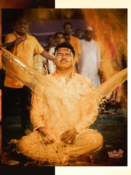 An action shot capturing the moment the groom is doused with turmeric water. It's a fun, unscripted part of the celebration that makes for a great memory.