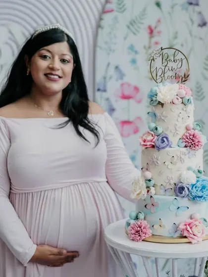 Here I am with the three-tier, all-buttercream cake for my own baby shower. This "Baby in Bloom" cake, with its hand-painted watercolor effect and sugar flowers, shows how I can create a stunning centerpiece for your most precious life moments.
