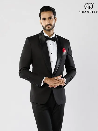 A closer look at the impeccable fit and finish of our classic tuxedo. Note the smooth satin lapel and the perfect placement of the bow tie, details that define our craftsmanship.