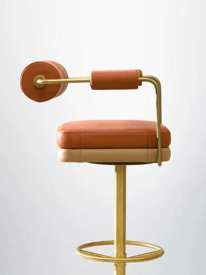 The side profile of our barstool highlights its sculptural form and the contrast between the soft leather and the gleaming metal. It's a piece designed to be admired from every angle.